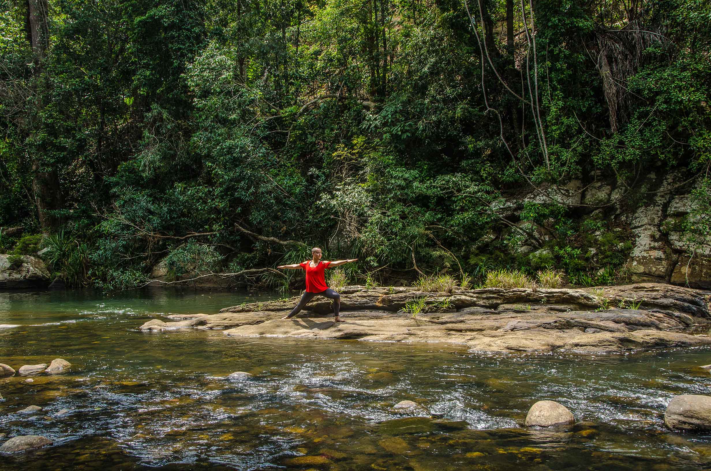 Practicing yoga by the river at Santani